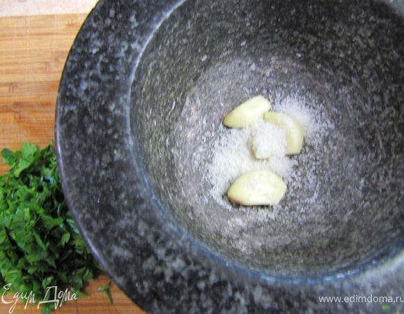 В ступке смешайте чеснок и немного крупной соли.