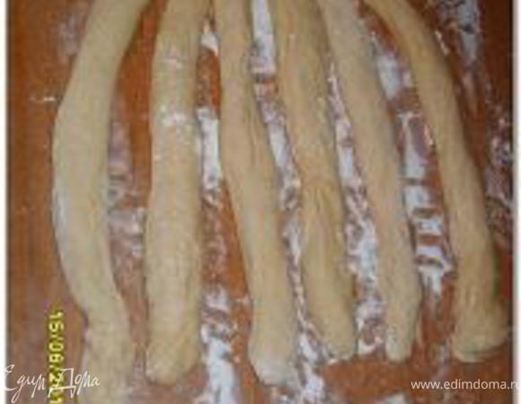 Выложить тесто на присыпанный мукой стол. Разделить на 6 частей, из каждого куска сформировать шар, накрыть и оставить на 15-20 минут. Из каждой части скатать жгут примерно 40 см длиной, концы жгутов сделать тоньше чем серединку; жгуты раскатывать от серединки к концам.

Соединить концы жгутов (отсчёт жгутов ведётся с лева на право), присыпать жгуты мукой, чтобы они не слиплись.