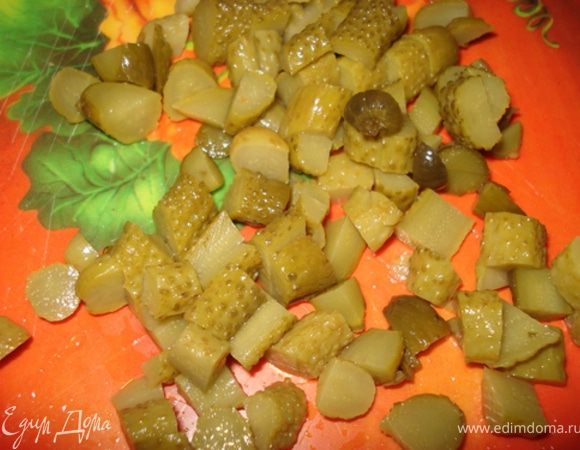 Корнишоны нарезать кубиками и добавить к овощам.