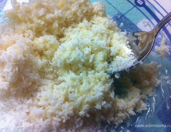 Перемешай сгущенное молоко с кокосовой стружкой. Раздели смесь на две чашки.