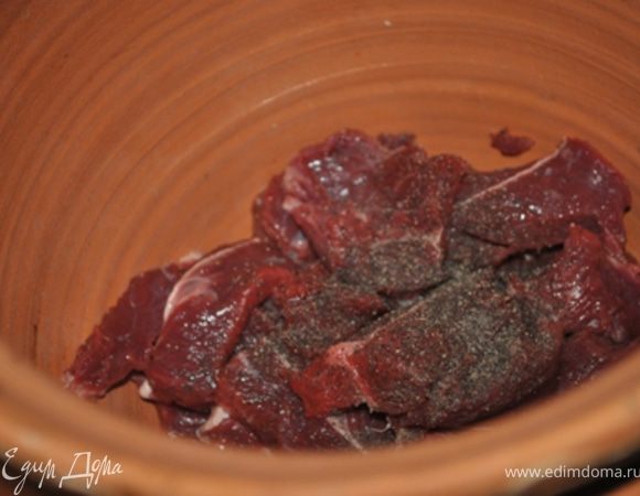 На дно глиняного горшка или чугунка положить ломтик сливочного масла и выложить мясо. Посолить, поперчить, положить лавровые листы.