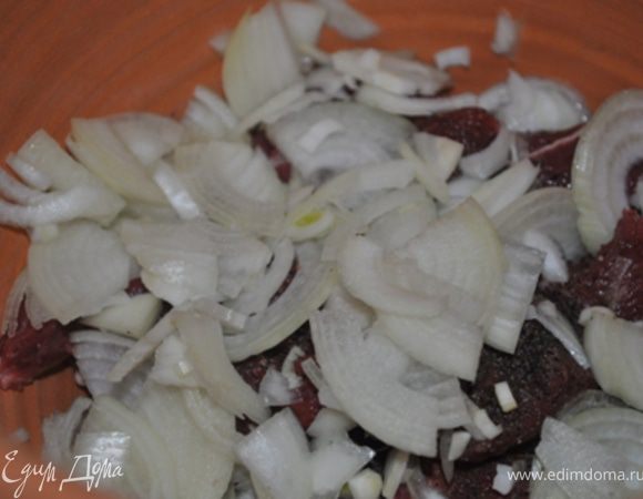 Лук порезать четверть-кольцами, выложить на мясо