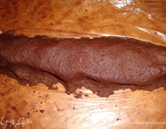 Добавить измельченный шоколад и быстро перемешать лопаточкой. Расстелить на рабочей поверхности кусок пленки размером примерно 30*40 см. Мне этого оказалось маловато, нужно было сделать 2 таких куска. Выложить на куски пленки тесто и сформировать колбаски диаметром примерно 4 см.