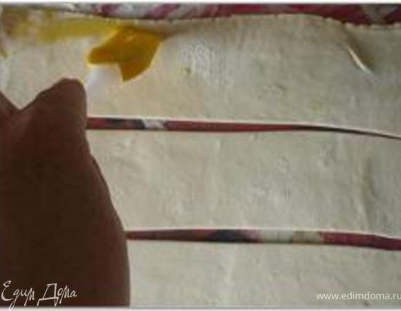 Яичный желток смешать с небольшим количеством воды и смазать им края полосок.