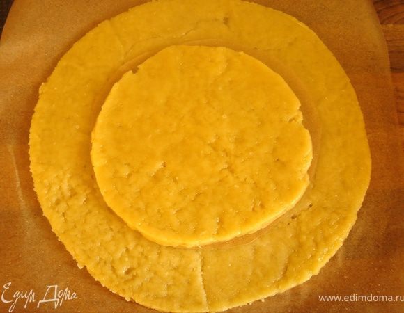 Тесто раскатать между листами пергамента(3мм),удалить верхний слой бумаги и вырезать два круга диаметрами 20 и 32 см(форма d=20  см).В маленьком круге вырезать небольшое отверстие.