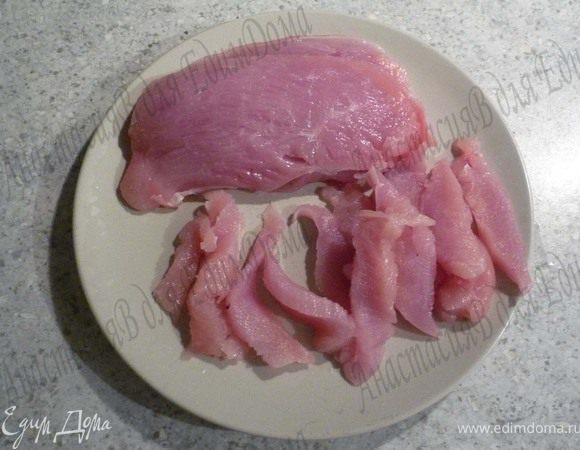 Филе индейки высушить кухонным полотенцем, нарезать небольшими полосками. Лук порезать кольцами, чеснок мелко порубить.