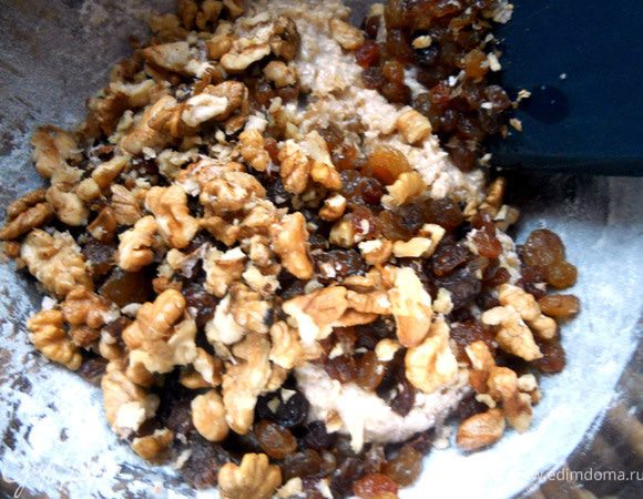 Добавить изюм (при необходимости предварительно распарить) и орехи. Замесить тесто.  