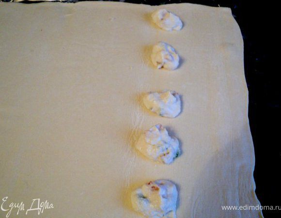 Слоеное тесто тонко раскатать ( у меня был готовый пласт  слоеное теста ),  на расстоянии 7 см от края выложить по чайной ложки начинки  с промежутком 7 см, 