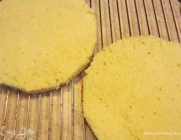 Разрежьте корж на два. Для этого возьмите длинный нож (лучше хлебный с волнистой кромкой) и пилящими движениями поворачивая корж разрежьте его. Так как у меня форма, в которой потом застывал торт была в размер с коржом, а начинка должна заходить и по бокам коржа, я слегка обрезал коржи, чтобы уменьшить диаметр.