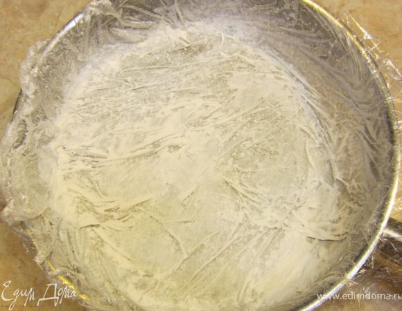 Смажьте пленку сливочным маслом. Высыпьте на масло сахарную пудру и поворачивая форму заставьте пудру прилипнуть к пленке со всех сторон. Остатки пудры высыпьте.
