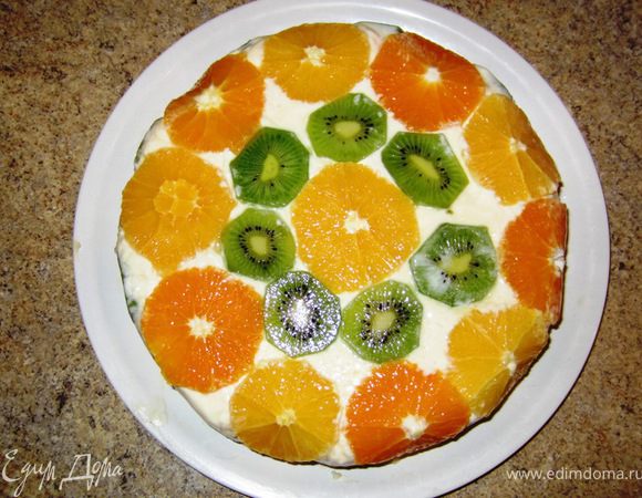 Положите сверху на корж тарелку, немного меньшего диаметра, чем форма, чтобы тарелка могла хорошо прижать коржи. Положите сверху груз 2 килограмма и выставьте форму на холод как минимум на четыре часа.