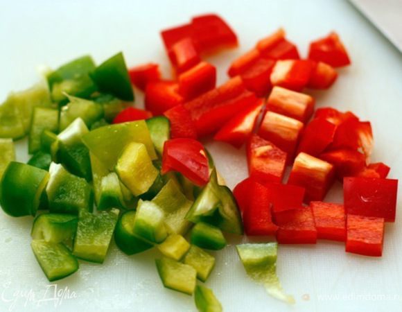 Разноцветный перец очистите от семян, нарежьте кубиками.