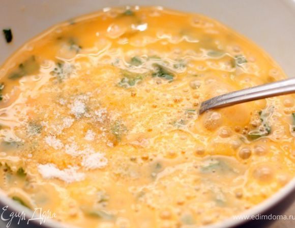 В отдельной миске слегка взбейте вилкой яйца с мелко нарезанной зеленью и солью.