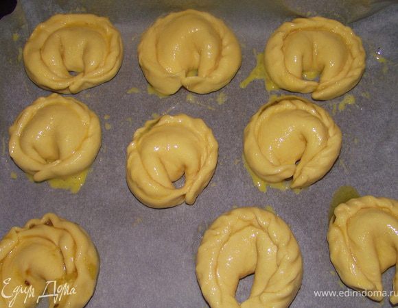 Взбить яйцо, смазать булочки. Выпекать при 200 °С, до золотистого цвета.