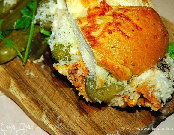 Готовое филе нарезаем тонкими ломтиками под углом. Теперь возьмем луковый хлеб и разрежем на две половинки. На нижнюю часть кладем салатный микст, затем выкладываем ломтики восхитительного пряного филе, между каждым кусочком цыпленка кладем тонкий ломтик маринованного корнишона. Сверху ложку йогурта или нежирного майноза и горсть тертого пармезана. Накрываем половинкой нашего лукового хлеба, слегка прижмем ладонью и наш неповторимый панини с пряным цыпленком готов.