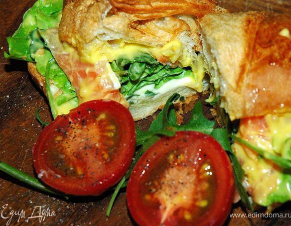 Теперь кладем лист свежего салата, можно чуть добавить рукколы, если любите. Теперь тонкие ломтики лосося, 2-3 штуки на один панини. Сверху поливаем горчичным соусом. Я брал готовый соус на основе сладко-острой горчицы, можете приготовить такой соус сами. Смешайте дижонскую и баварскую горчицы, добавьте немного йогурта или сметаны и соус готов. Он очень классно сочетается с соленой рыбой. Накрываем наш панини верхним куском круассана и самый вкусный быстрый ланч у вас «в кармане». Добавьте к такому панини чашку ароматного кофе, и вы не останетесь голодным в течение дня. Приятного аппетита!

