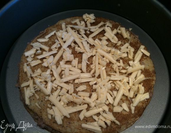 Накрыть фарш блином и сверху выложить натертый сыр. 