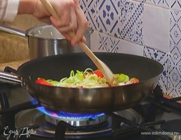 Разогреть в сковороде 1 ст. ложку оливкового масла, слегка обжарить порей и чеснок. Добавить сладкий перец, перемешать и обжаривать 1–2 минуты.