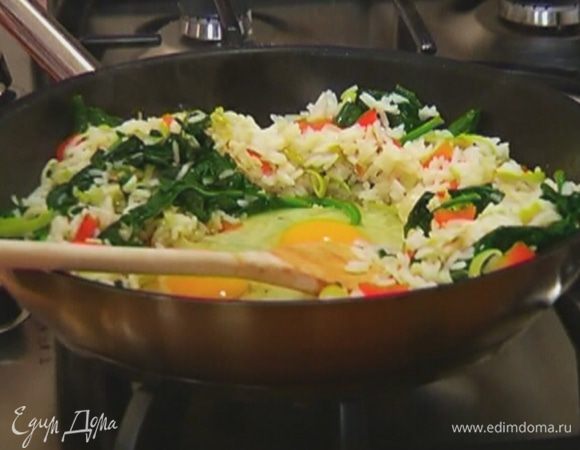 Отодвинуть рис с овощами к стенкам сковороды, в середину разбить яйца и, помешивая, обжарить их, затем перемешать с рисом.