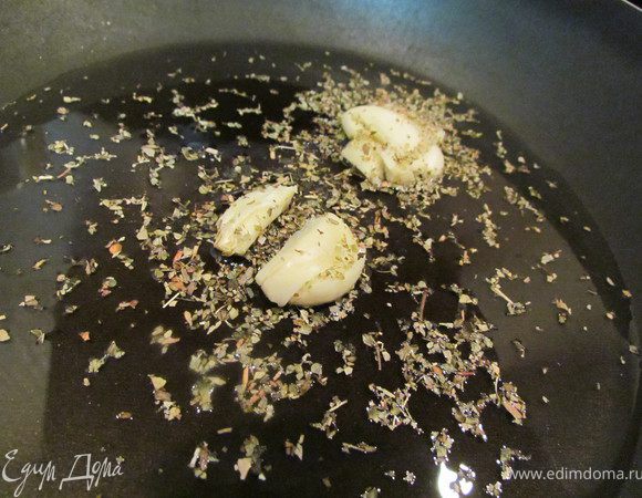 Влить на сковородку оливковое масло и слегка обжарить в нем раздавленный чеснок, посолить его немного и всыпать орегано! 
