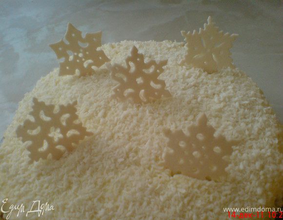 Утром вынимаем торт из формы. Посыпаем кокосовой стружкой и украшаем снежинками из мастики.