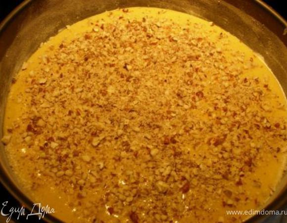 Форму смазать сливочным маслом и посыпать мукой и сахарной пудрой (взять в равных пропорциях, например: 1 ч. л. муки и 1 ч. л. мудры). Выложить в форму тесто, сверху посыпать орехами.