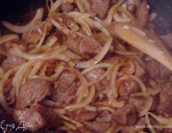 Лук нарезать полукольцами, чеснок измельчить и добавить все в мясо, обжарить до золотистого цвета.