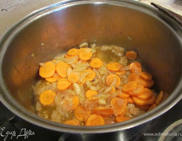 Нарезать кружками морковь и добавить к луку и чесноку, томить минут 5.