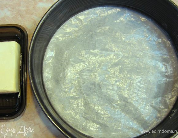 Возьмите разборную форму. Выстелите дно пергаментной бумагой. Ровный круг можно вырезать, сложив бумагу как для снежинки несколько раз и отмерив половину диаметра формы (радиус) отрезать лишнее. Смажьте форму вместе с бумагой сливочным маслом.