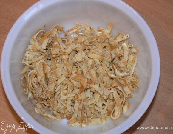 Из яиц сделать блинчики: взболтать яйца вилочкой, добавить соль,перец,и 1ст.л крахмала. Выпечь 4-5 блинчика. Свернуть их рулетиками и нарезать тонкой "лапшой".