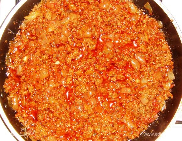 За это время приготовим начинку. Для этого говяжий и куриный фарш обжарим до полуготовности в растительном масле с добавлением 100мл воды (крышку накрыть и протушить). В фарш добавляем лук, нарезанный крупным кубиком, солим, заправляем специями.
В конце добавляем томатную пасту и протушиваем ещё 2-3 минуты. 