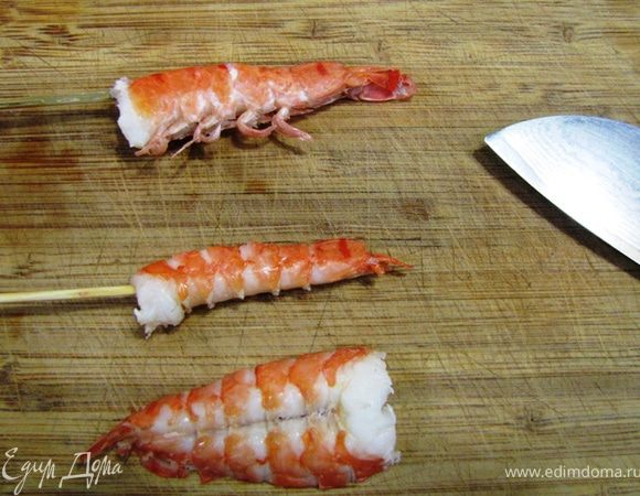 Снимите кожуру с креветки, затем снимите креветку со шпажки.
Разрежьте креветку со стороны спины вдоль почти до конца. Разверните креветку, как это показано на фотографии и удалите кишечник.