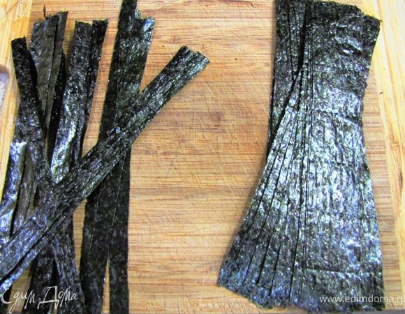 Нарежьте листы водорослей Нори на полоски шириной в три сантиметра. Просто ножницами как бумагу.