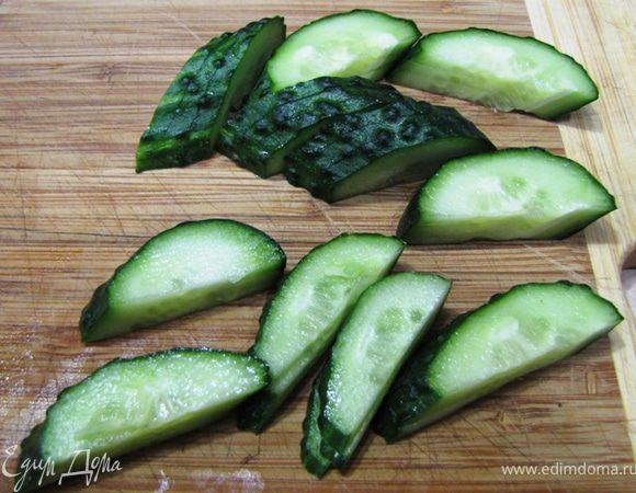 Огурец разрежьте вдоль пополам. Затем каждую половинку нарежьте под углом не прорезая с одной стороны до конца. Таким образом у вас получится что-то вроде веера. Отделите друг от друга по три "лепестка". Эти лепестки будут использоваться для Гунканмаки. Второй огурец просто порежьте на полоски толщиной, аналогичной полоскам рыбы.