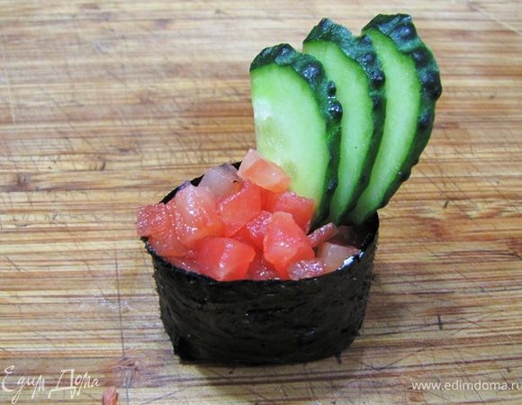 Теперь готовим три варианта Гунканмаки.

Саке Гунканмаки
Возьмите подготовленный "боевой корабль". Положите пол чайной ложки сыра и распределите его по рису.
Положите сверху порезанную кубиками рыбу.
Слегка раздвиньте кусочки огурца, которые вы раньше подготовили, чтобы получился веер.
Воткните сбоку веер.
Саке Гунканмаки готов