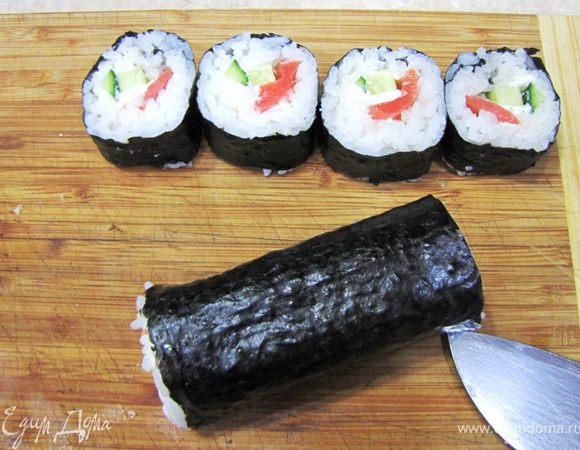 Смочите нож еще раз. Если на ноже остались следы риса, тщательно смойте его, иначе будет трудно разрезать дальше ролл.
Разрежьте каждую половинку ролла еще раз пополам. После второго смачивания ножа, разрежьте каждую четвертинку еще раз пополам.
В итоге из одного ролла у вас должно получиться восемь кусочков.