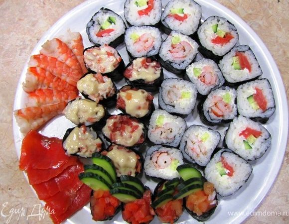 Итак имеем на каждую порцию:
Гункамимаки - 3 шт с различными вариантами начинки
Маки (ролы) - 4 шт по две с различными вариантами начинки.
Примерно по три креветки и три кусочка рыбы в качестве Сашими.

Лично я выложил все суши на одно блюдо.
Подавайте суши с соевым соусом (для каждого гостя в отдельной посуде), маринованным имбирем и вассаби.
Очень хорошо с суши идет зеленый чай Моргентау (или Грюн Матине) - по крайней мере именно такие названия я слышал.