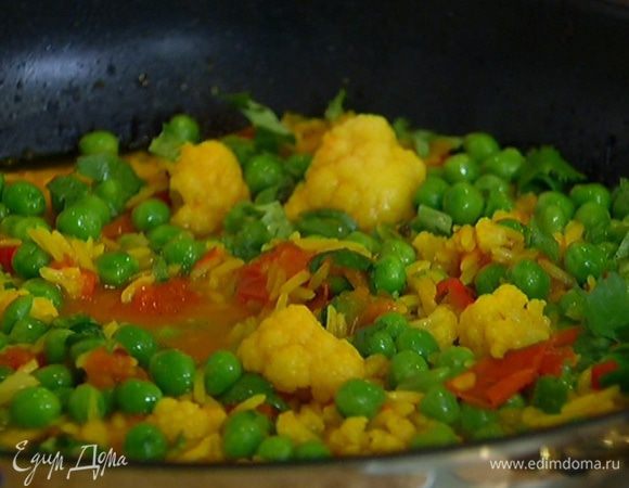 Добавить к рису зеленый горошек и кинзу, перемешать и держать на огне еще 5 минут.