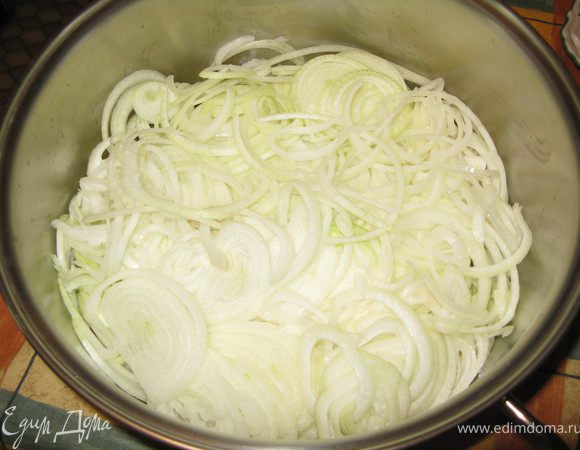 Отдельно готовится второй важнейший ингредиент фарша - лук. Он шинкуется кольцами, а дальше выкладывается в  большую и широкую кастрюлю с толстым дном, или в казан. 