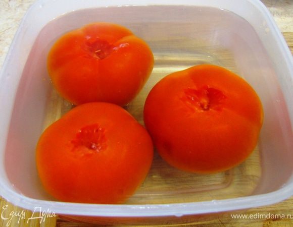Возьмите помидоры и вырежьте плодоножку. Залейте помидоры кипятком на несколько минут. Можете положить их в кастрюлю с кипящей водой. Кроме того, помидоры можно потереть довольно сильно тупой стороной лезвия ножа до потемнения. В любом из этих случаев кожица будет легко слезать с овоща. Снимите кожицу с помидоров.