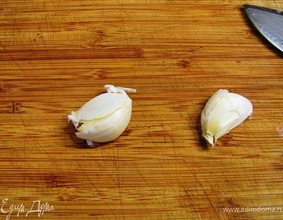 Плоской стороной ножа ударьте по зубчикам чеснока, чтобы кожица лопнула. Так легче будет снять кожицу.