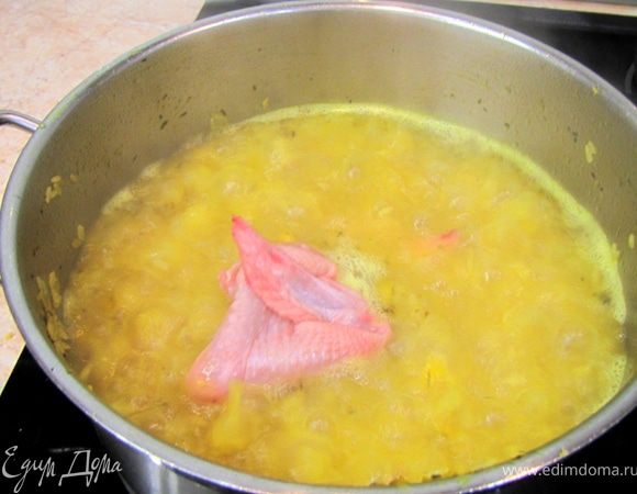 В этот момент (бурного кипения) выложите сырые крылышки в кастрюлю, не забывая утапливать их в рисе. Этот способ аналогичен обжариванию. Кипяток обваривает поверхность крылышек, сохраняя при этом сок мяса внутри.