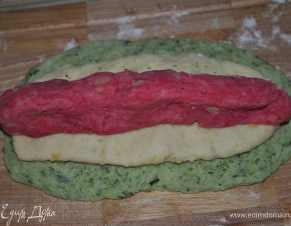 Берем оставшееся тесто. Из зеленого делаем тонкую лепешку, сверху кладем белую лепешку, поменьше размером, и в центр красную.