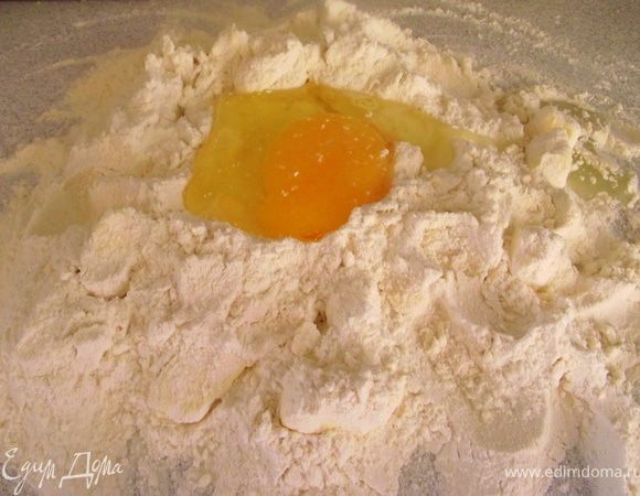 На рабочую поверхность просейте муку, добавьте сливочное масло и покрошите его ножом. Сделайте углубление, в него вбейте яйцо и добавьте две столовые ложки ледяной воды. Замесите тесто.