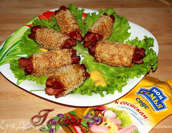 На блюдо выкладываем листья салата для каждой сосиски.
В салатный лист - немножко горчичного соуса
и положить сосиски в каждый листик.