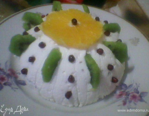 Желатин замочить на полчаса в молоке. В это время порезать  фрукты У меня бананы, ананасы и персики консервированные, изюм, жареные орехи. Можно использовать также ягоды, варенье, джемы, порезанный мармелад. Творог хорошо взбить в блендере с сахаром, затем добавить сметану и взбитые сливки. 
Добавить в творожную массу ванильный сахар, порезанные фрукты, изюм и орехи, все перемешать(можно так же тертый шоколад). 
Желатин подогреть на водяной бане до растворения, влить в творожную массу, перемешать. Формочку застелить фольгой или пищевой пленкой. Влить творожную массу, поставить на холод для застывания. 
Когда десерт застынет, перевернуть на тарелку и украсить. Сверху положить кружочек апельсина, по бокам вставить киви, между киви гранат и сверху потереть шоколад.


