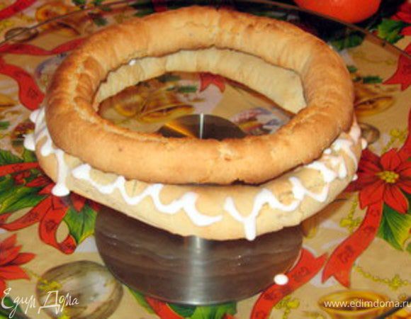 Приготовить глазурь, взбив белок с сахарной пудрой и лимонным соком. Взять небольшой пластиковый мешочек, влить туда готовую глазурь, срезать уголок и укарасить торт. Глазурь нужна не только для красоты,но она служит для скрепления колечек между собой. Когда пирамидка готова,украсьте по желанию. 



