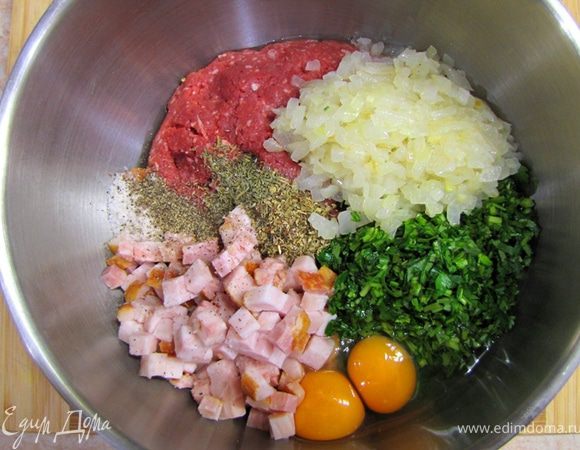 Добавьте туда хлебные крошки, порубленую грудинку, зелень, яйца, остывший зажаренный лук, сушеные травы, потрите мускатный орех, черный перец.
Влейте коньяк и посолите. Потрите цедру лимона.