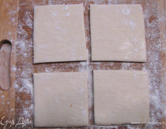 Берем пласт мороженого теста и размораживаем его на столе, предварительно посыпав мукой.
Кладем тесто на доску и разрезаем на 4 части. Конечно можно воспользоваться формочками и вырезать красивые кружки. Но мне стало жалко теста и я просто разрезал на 4 части.