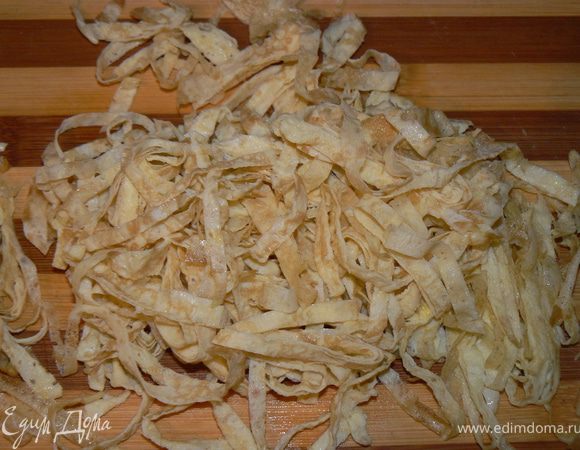 Яйца соедините с водой и поджарьте тонкие омлетные блинчики. Остудите, нарежьте тонкими лентами.